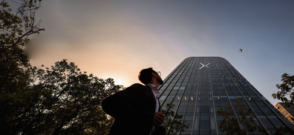 A man looking up at a tower at dusk